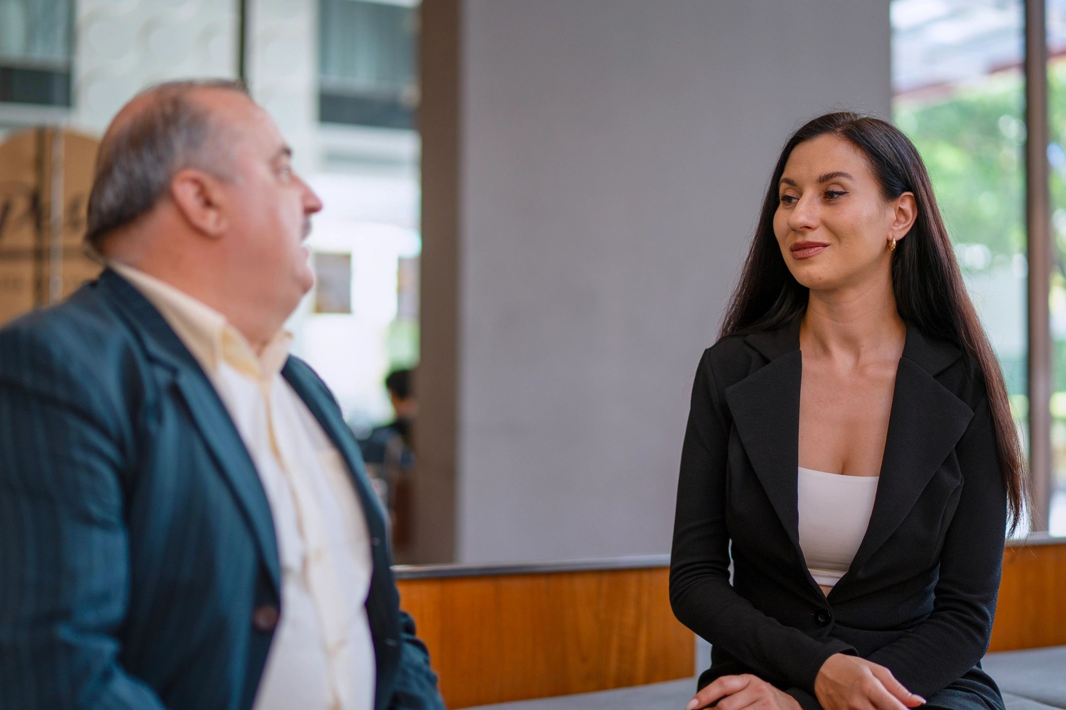 People in white collar jobs are meeting together in the lobby of a hotel.